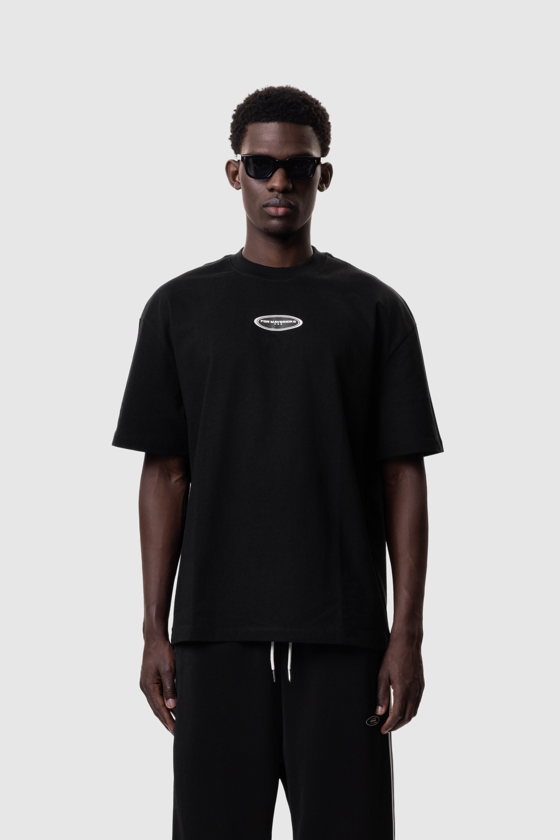 Person wearing a black t-shirt with a logo on a white background