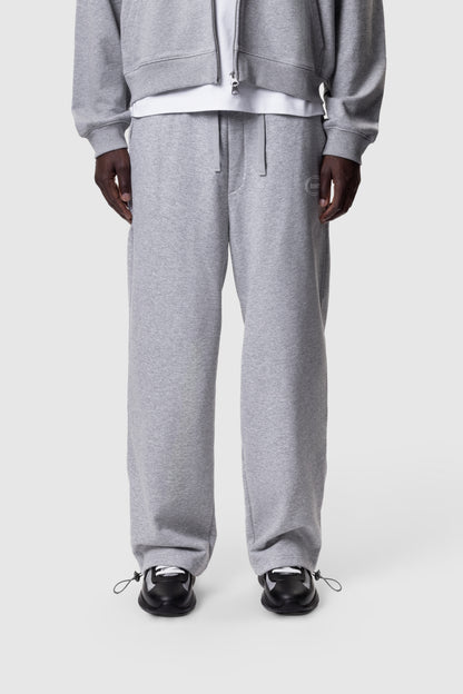 Person wearing a grey tracksuit on a white background